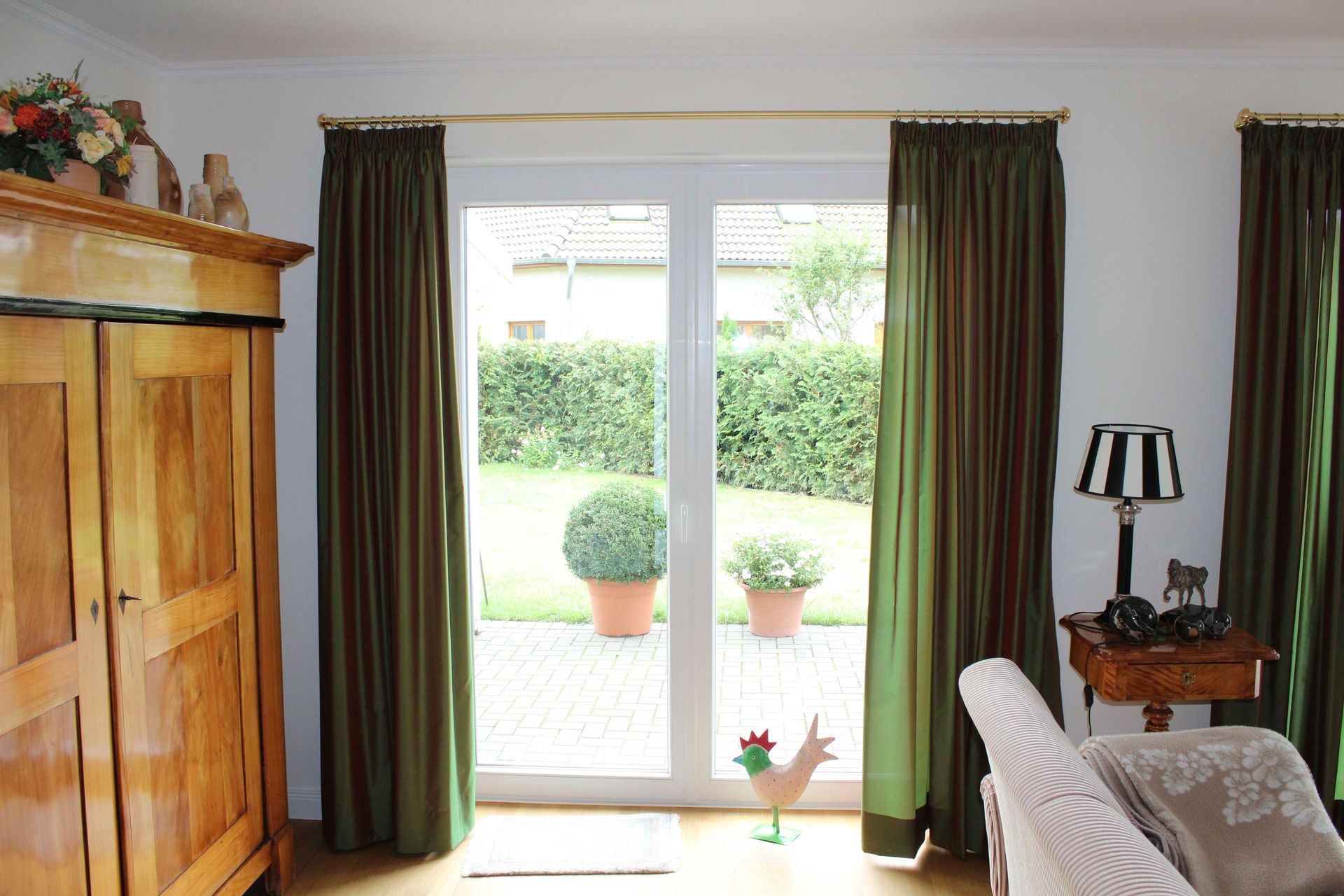 Ein Wohnzimmer mit grünen Vorhängen und einer Glasschiebetür