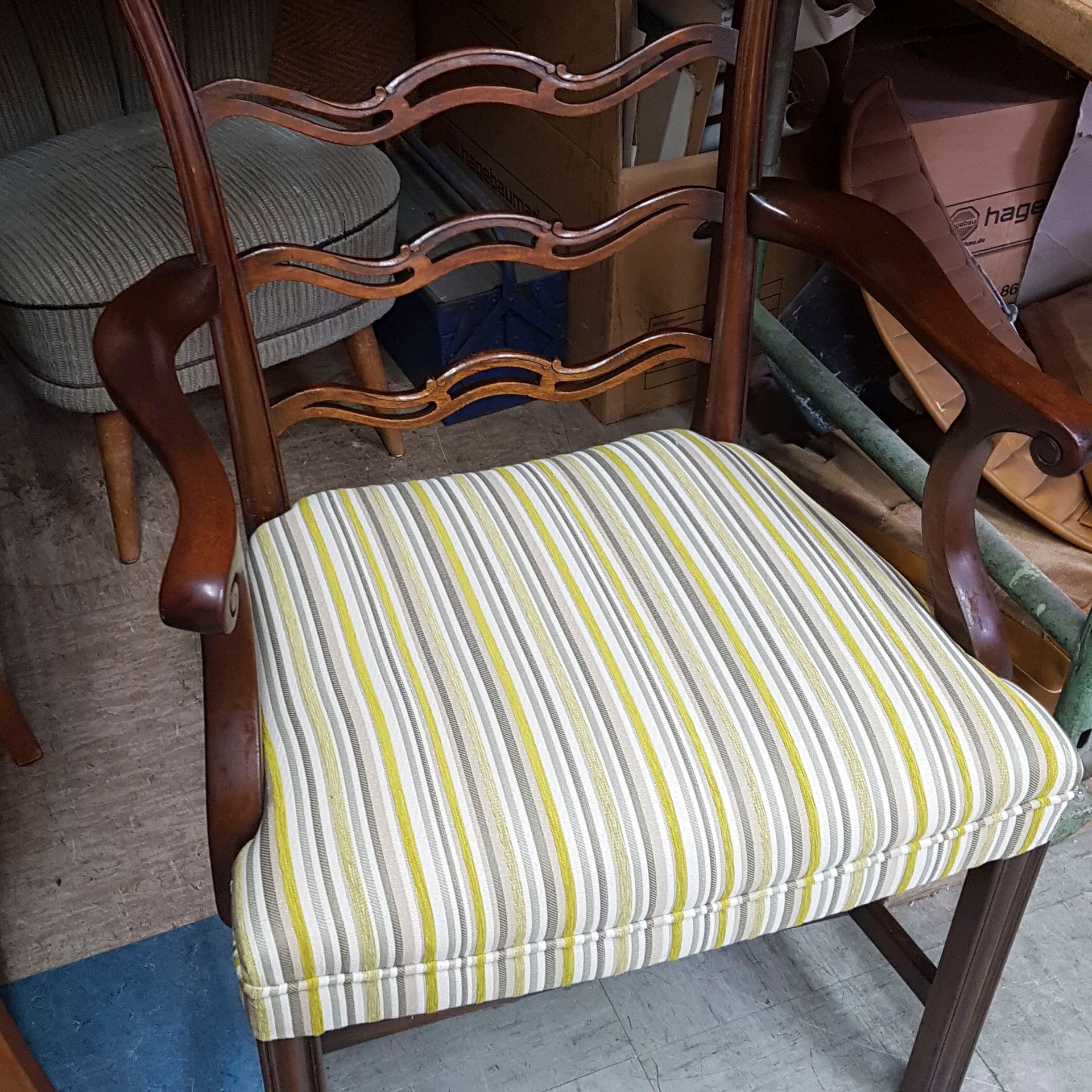 Ein Holzstuhl mit gestreiftem Sitzkissen