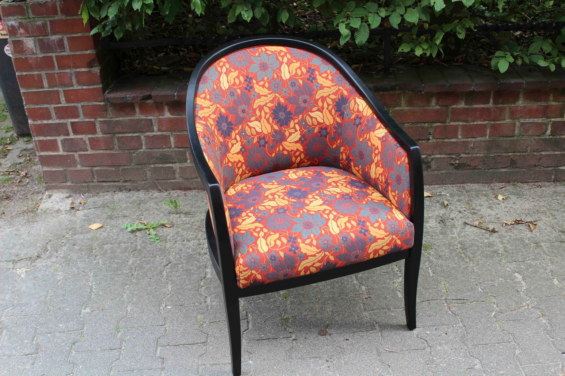 Ein Stuhl mit einem Muster steht vor einer Backsteinmauer