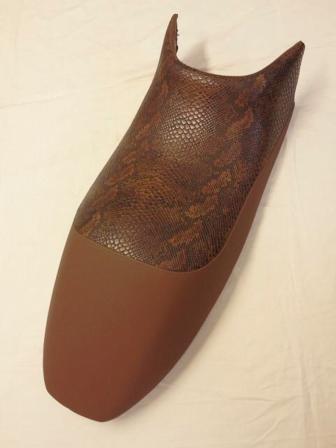Ein brauner Motorradsitz mit einem Schlangenhautmuster darauf