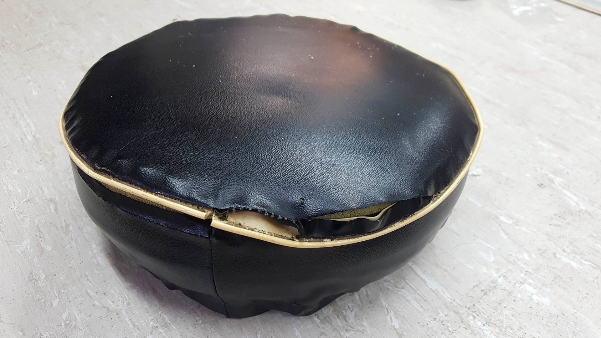 Auf einem Tisch liegt ein schwarzes Kissen mit einem Loch darin.