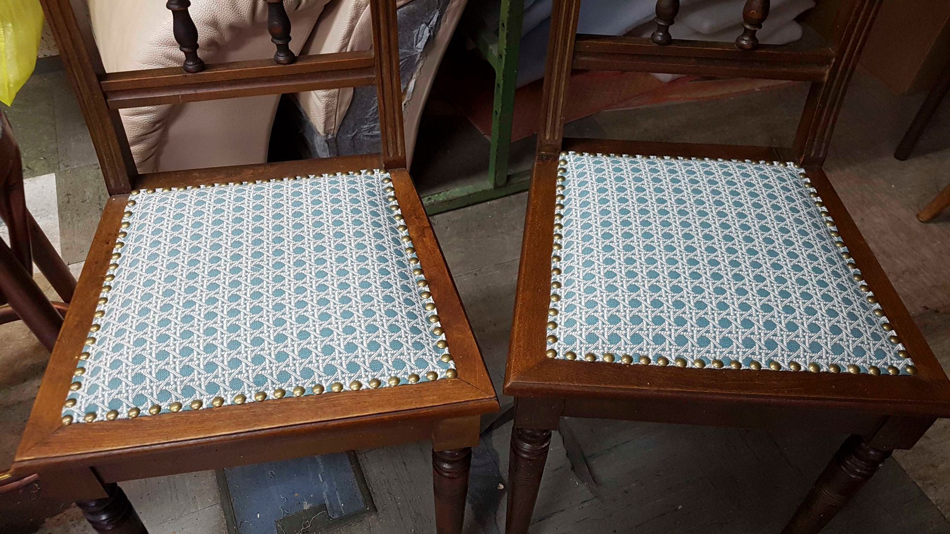 Zwei Stühle mit blauen Kissen stehen nebeneinander auf dem Boden.