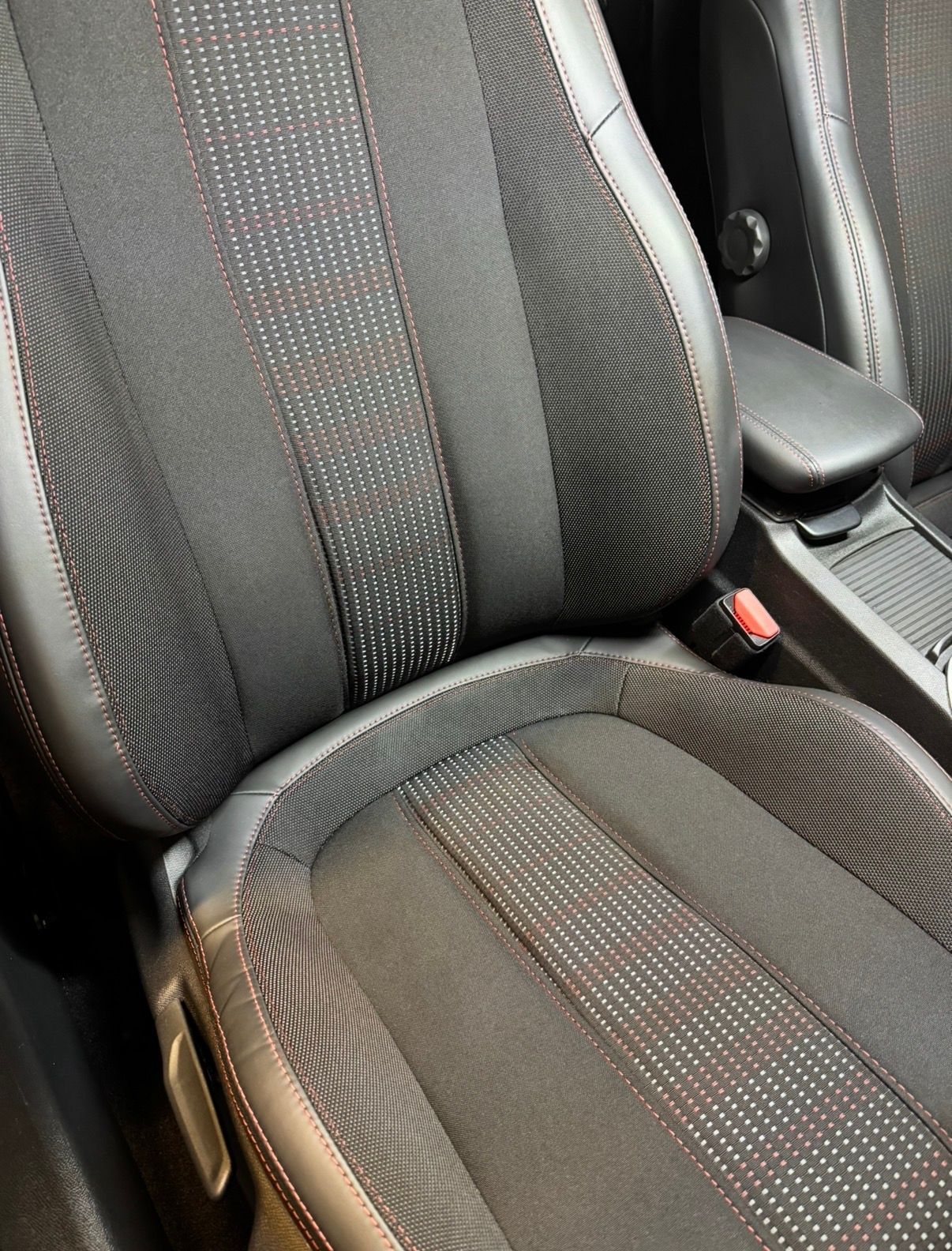 Gros plan sur un siège auto avec un revêtement à rayures foncées et des coutures apparentes propre.