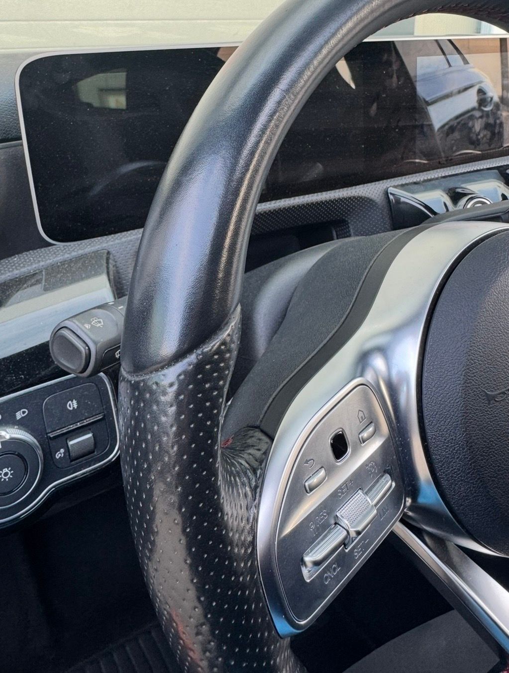 Gros plan sur un volant de voiture avec boutons de commande et tableau de bord en arrière-plan. Volant sale.
