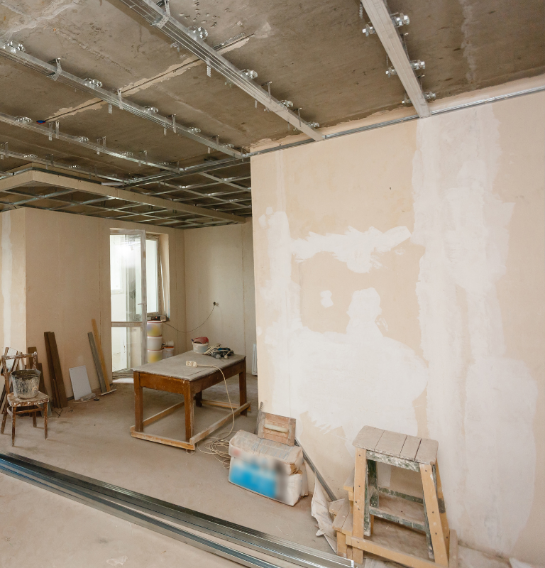 Une pièce en construction avec une table et des chaises