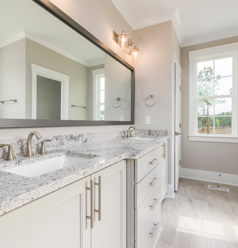Une salle de bain avec deux lavabos et un grand miroir