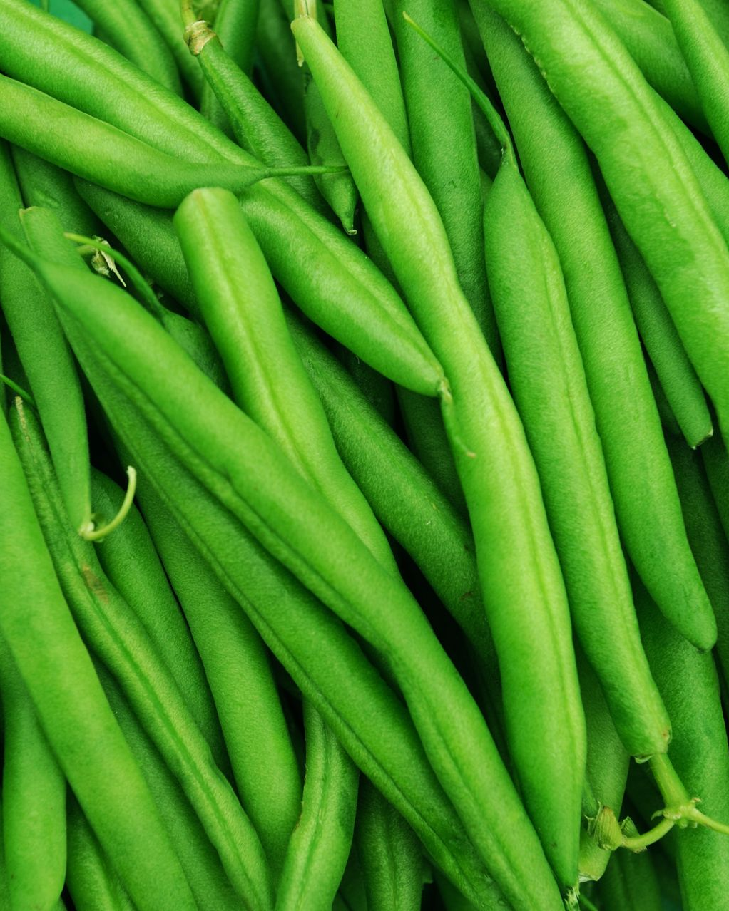 Tas de racines de manioc brunes avec de la terre et de la chair rosâtre.