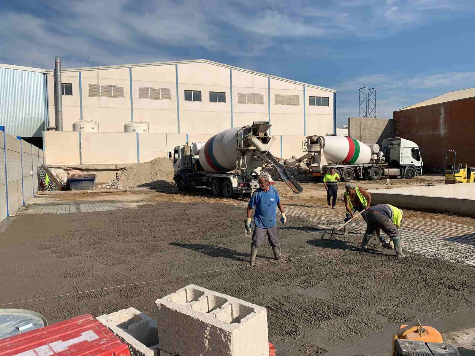 Obreros de la construcción vierten hormigón con hormigoneras.