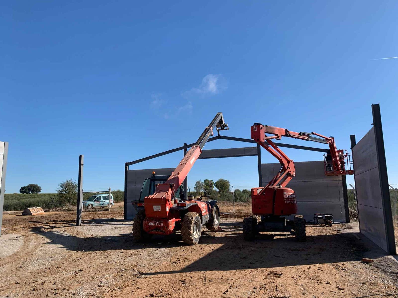 Sitio de construcción: una carretilla elevadora roja y una plataforma elevadora.
