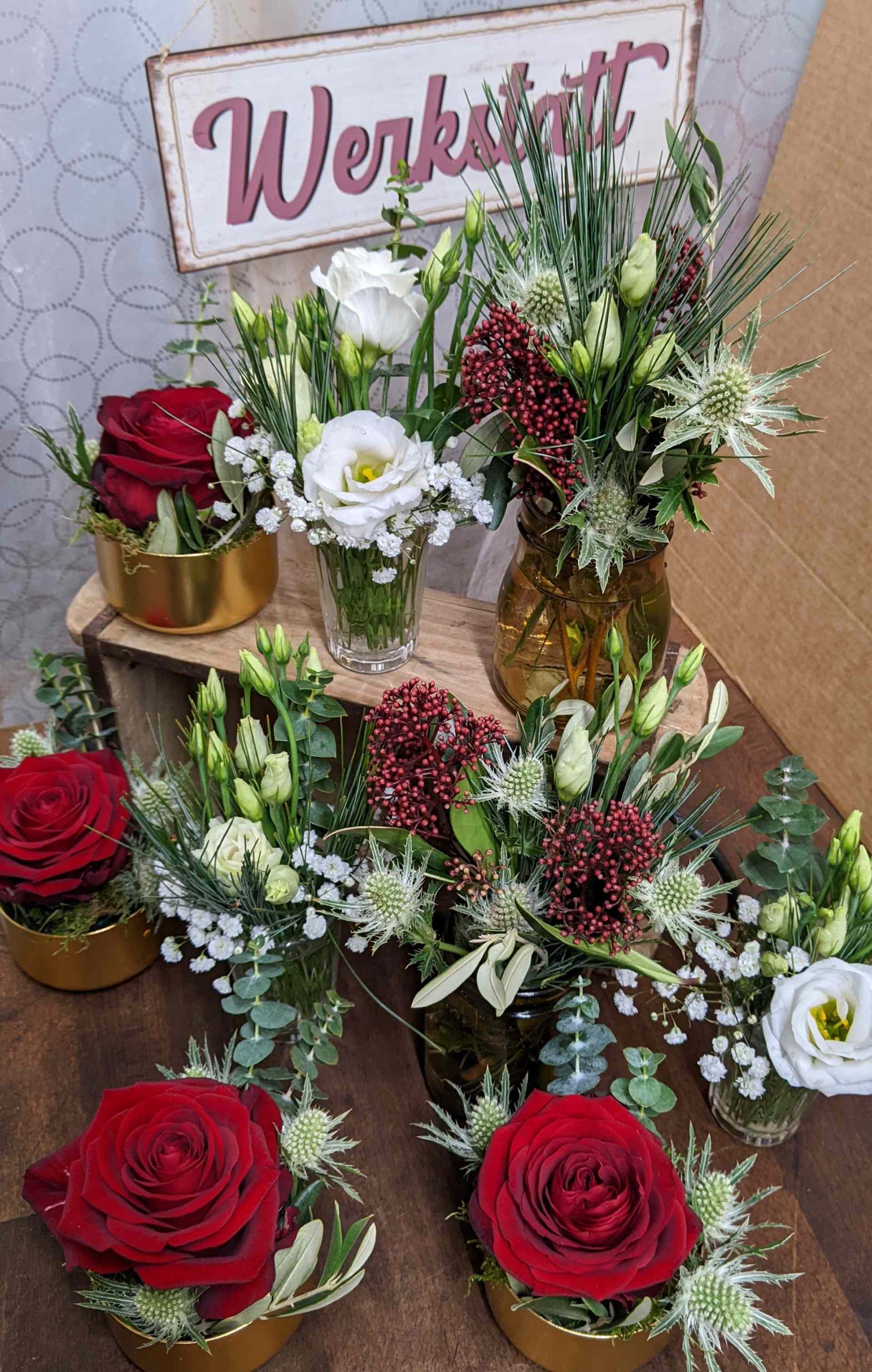 Tischset mit verschiedenen Blumengestecken für eine Werkstatt.