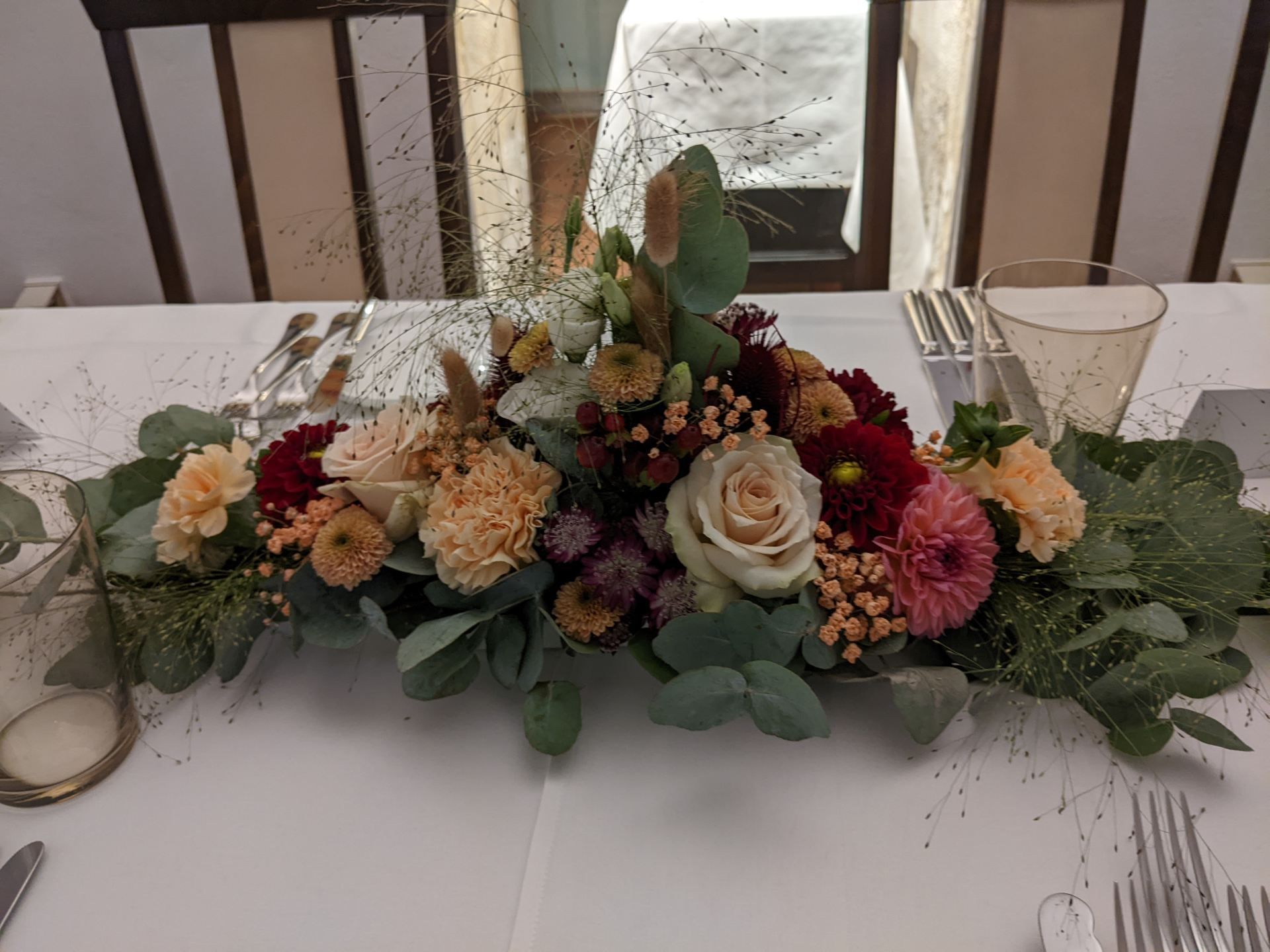 Tischset mit verschiedenen Blumengestecken für eine Werkstatt.