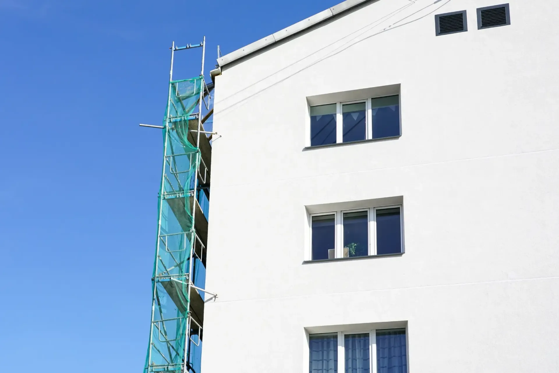 Fachada de un edificio en proceso de pintura y arreglos.