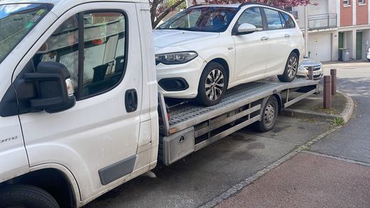 Voiture blanche chargée sur un véhicule de remorquage