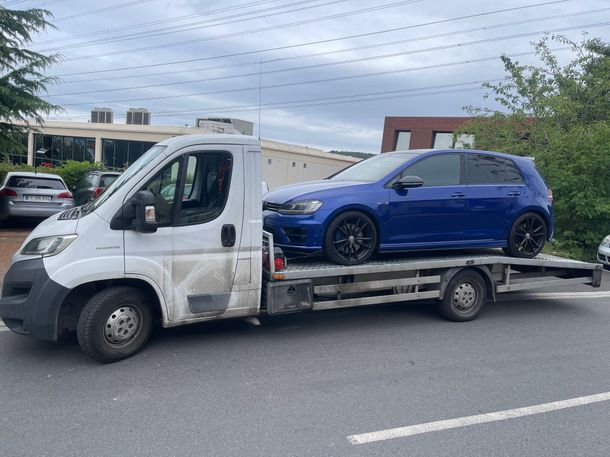 Remorquage d'une voiture bleue à l'aide d'un véhicule blanc