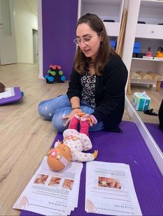 María Ruiz realizando un ejemplo de fisioterpia con un muñeco bebé