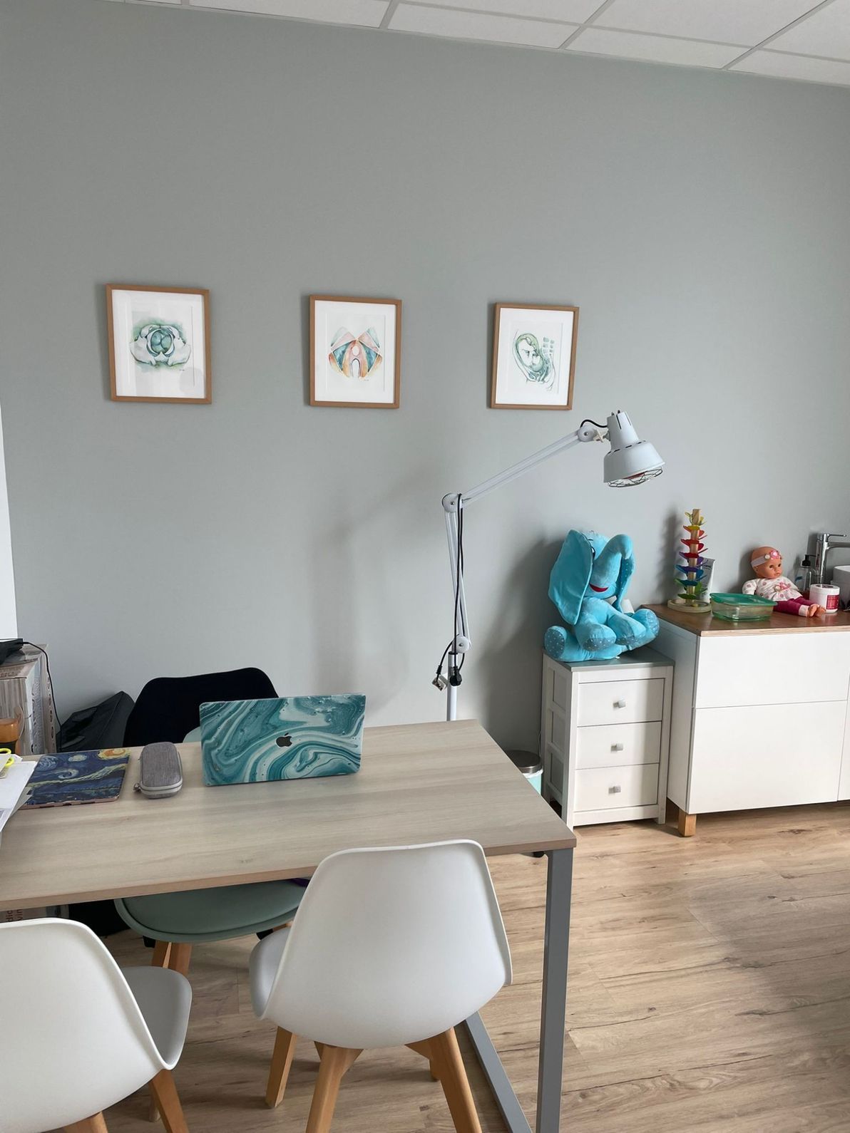 Un consultorio médico con una mesa y sillas.