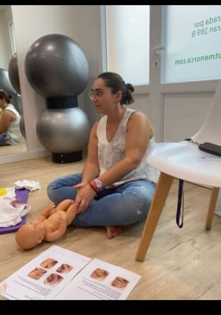 María Ruiz realizando un ejemplo de fisioterpia con un muñeco bebé