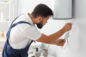 Un plombier réparant une unité de chauffage.
