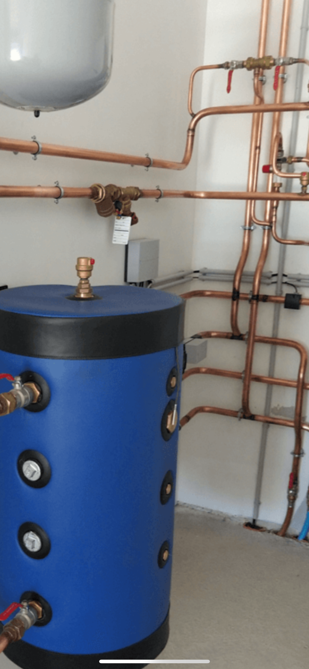 Une unité de chauffage noir et bleu avec des tuyaux en cuivre.