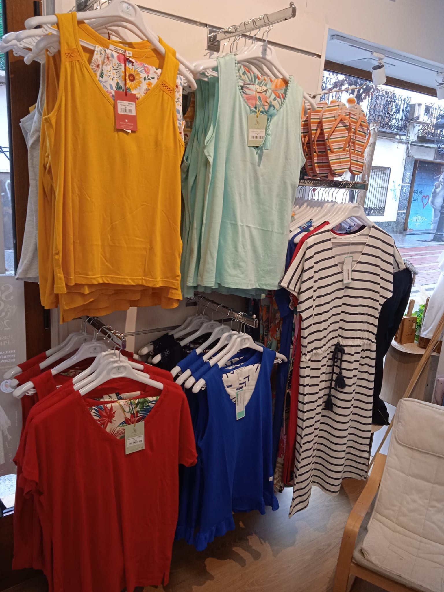 Un montón de ropa está colgada en un perchero en una tienda.