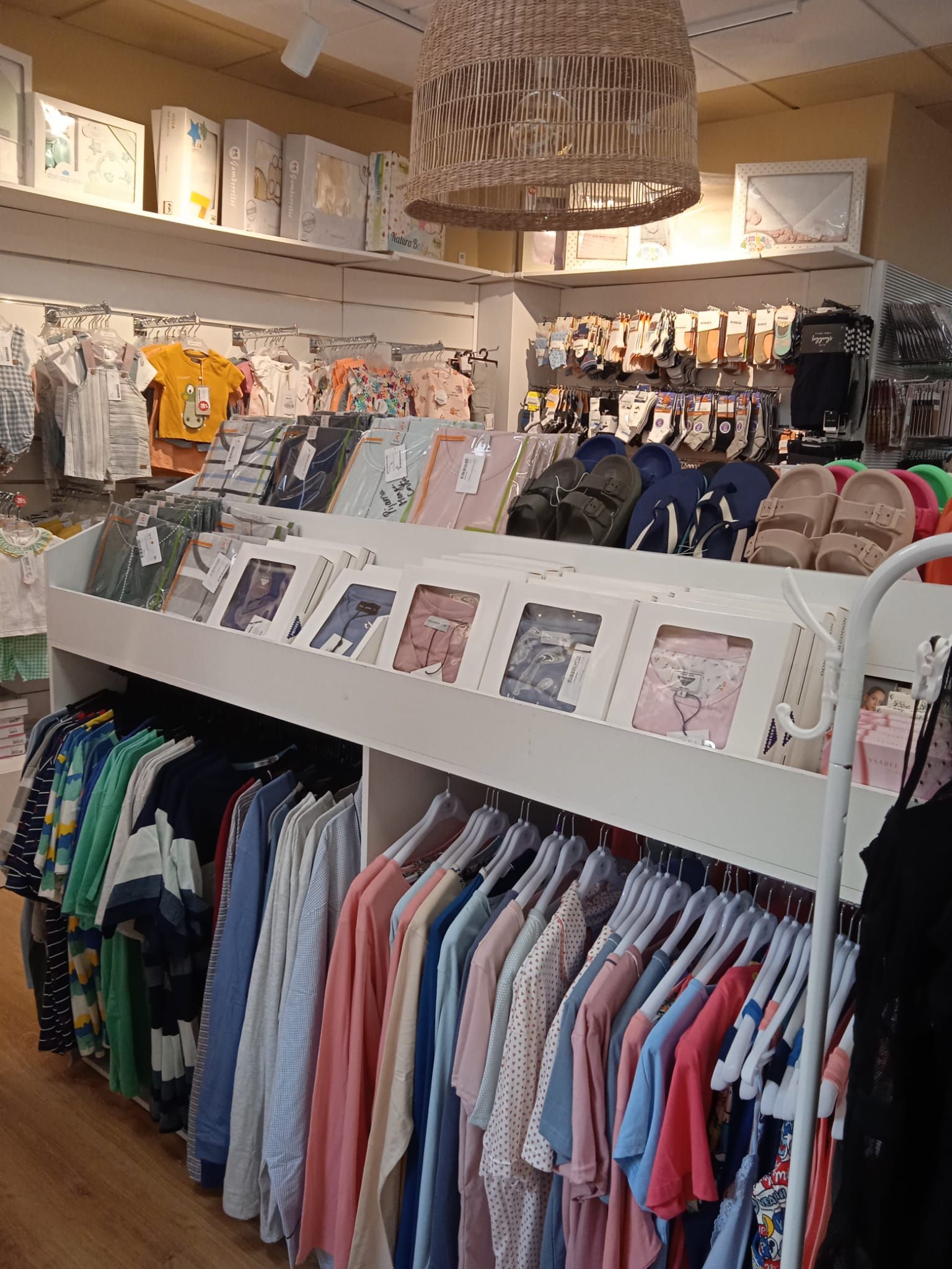 Una tienda llena de ropa colgada en percheros.