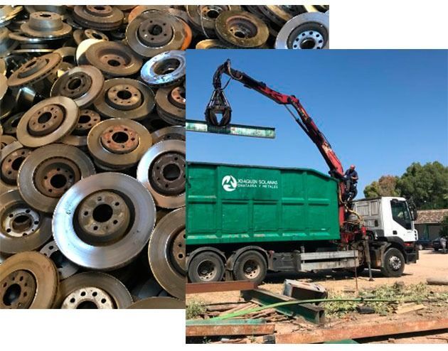 Una pila de discos de freno junto a un camión de basura verde