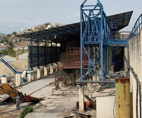 Un hombre está parado frente a un edificio que está en construcción.