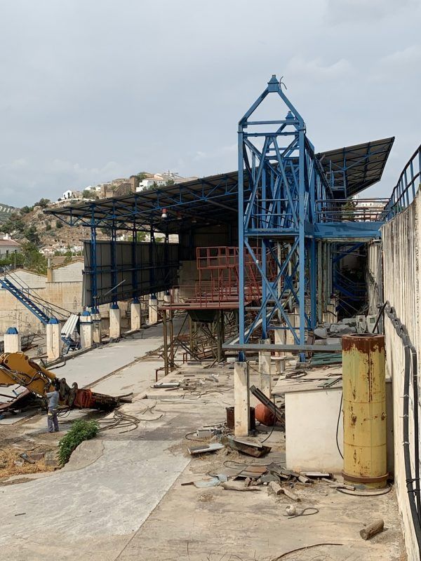 Un sitio de construcción con una gran estructura azul al fondo.