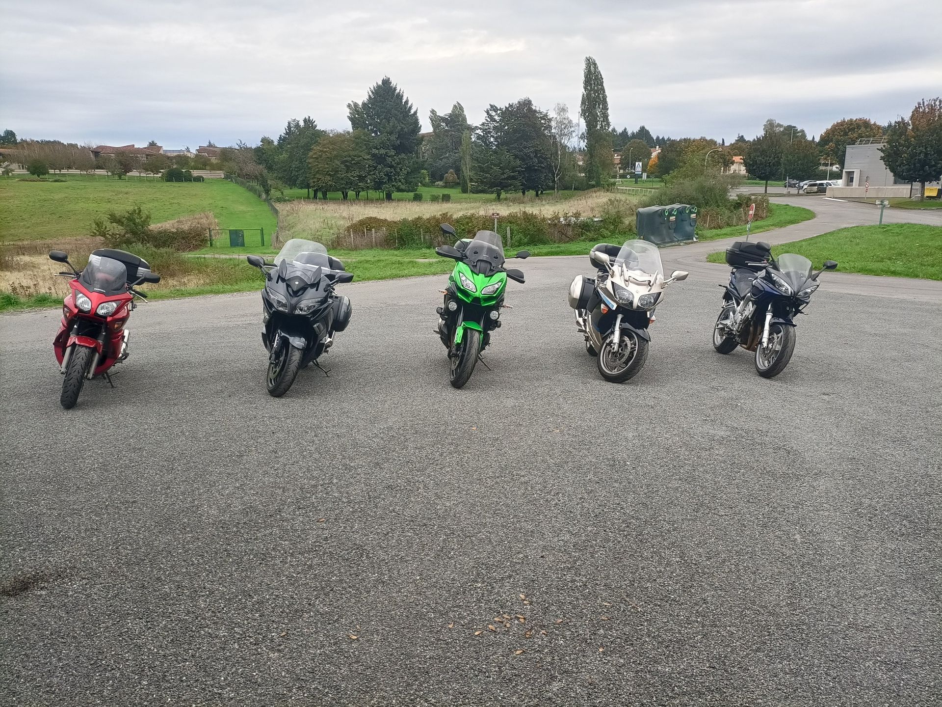 Cinq motos garées sur du gravier.