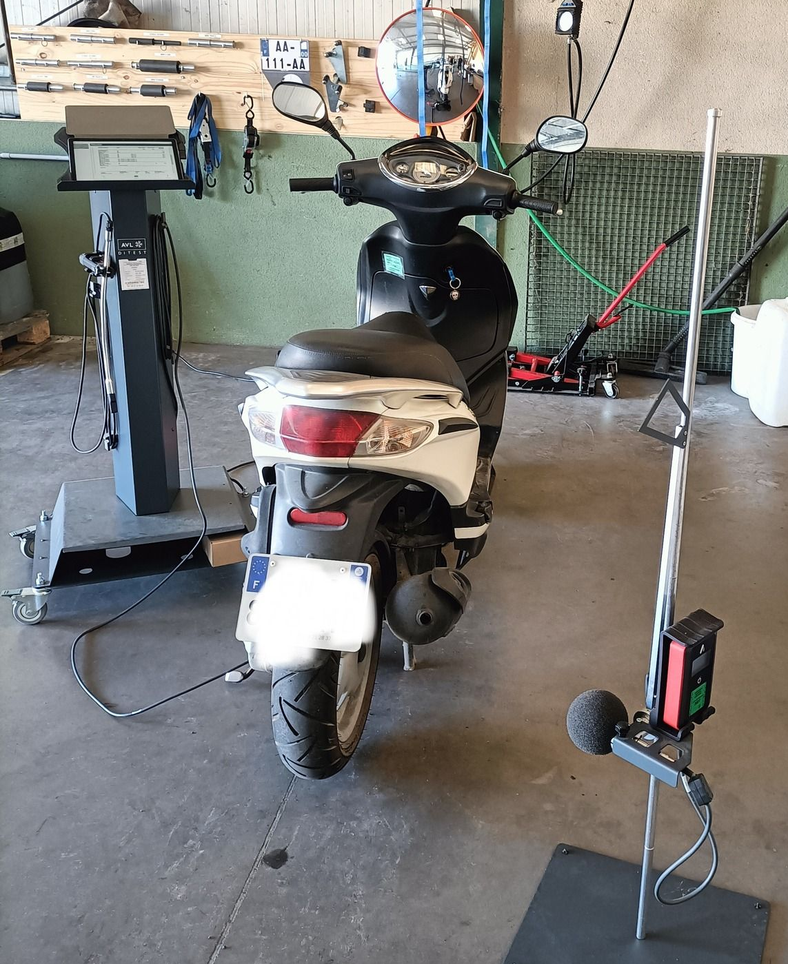 Un scooter est inspecté dans le centre de contrôle technique.