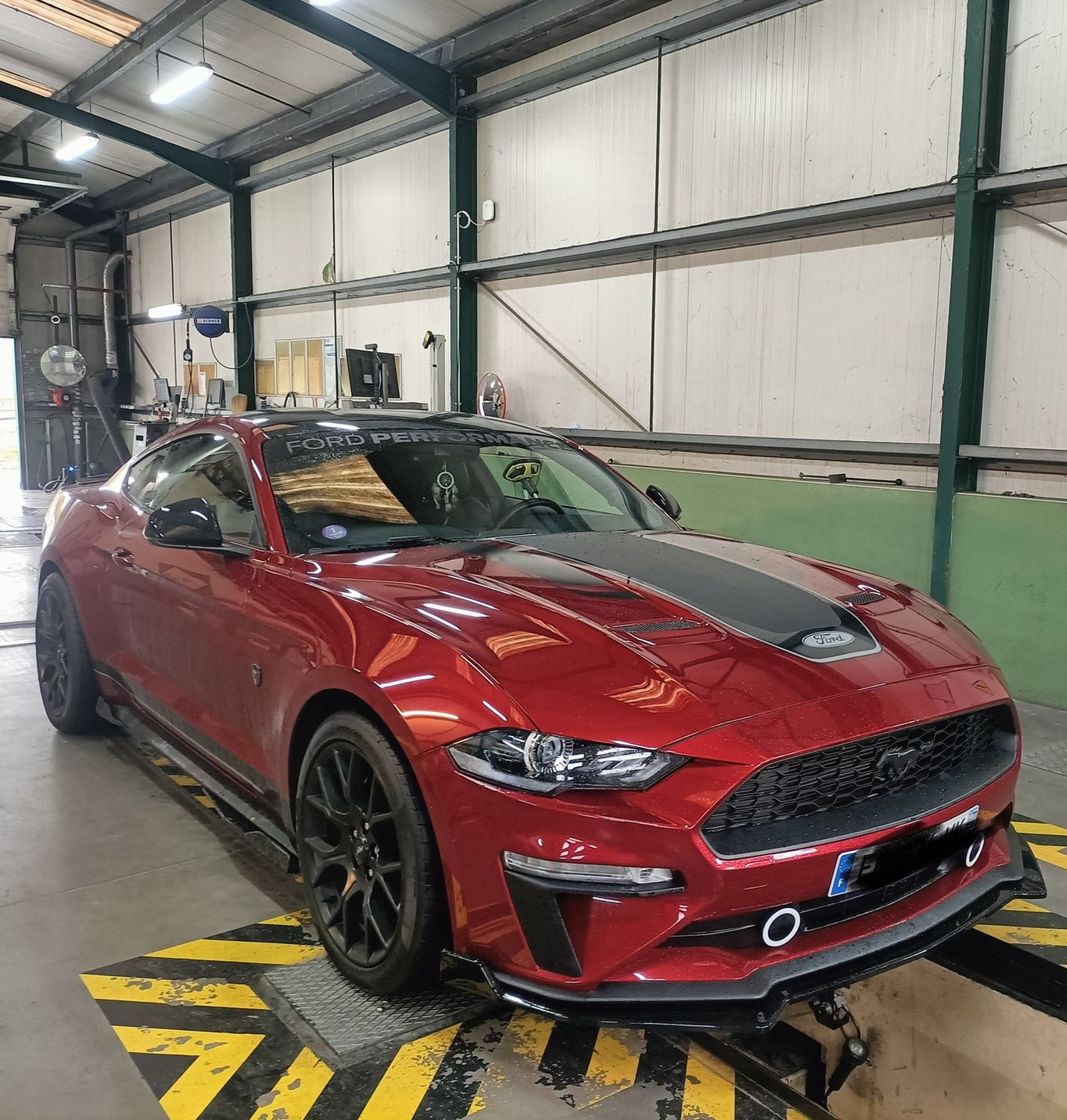 Coupé Ford Mustang rouge à l'intérieur du centre DEKRA.