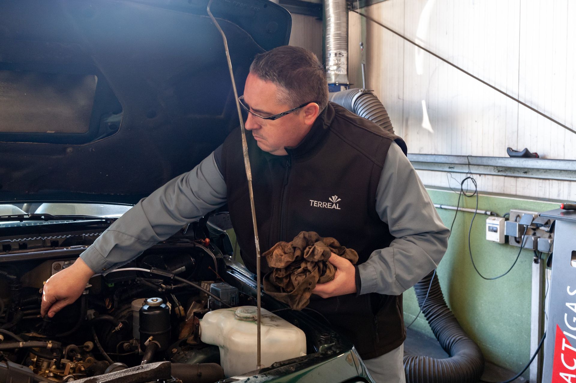 Un mécanicien inspecte le moteur d'une voiture.