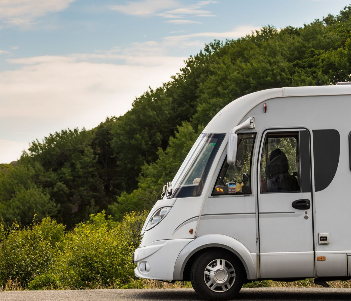 Un camping-car blanc sur une route de campagne.