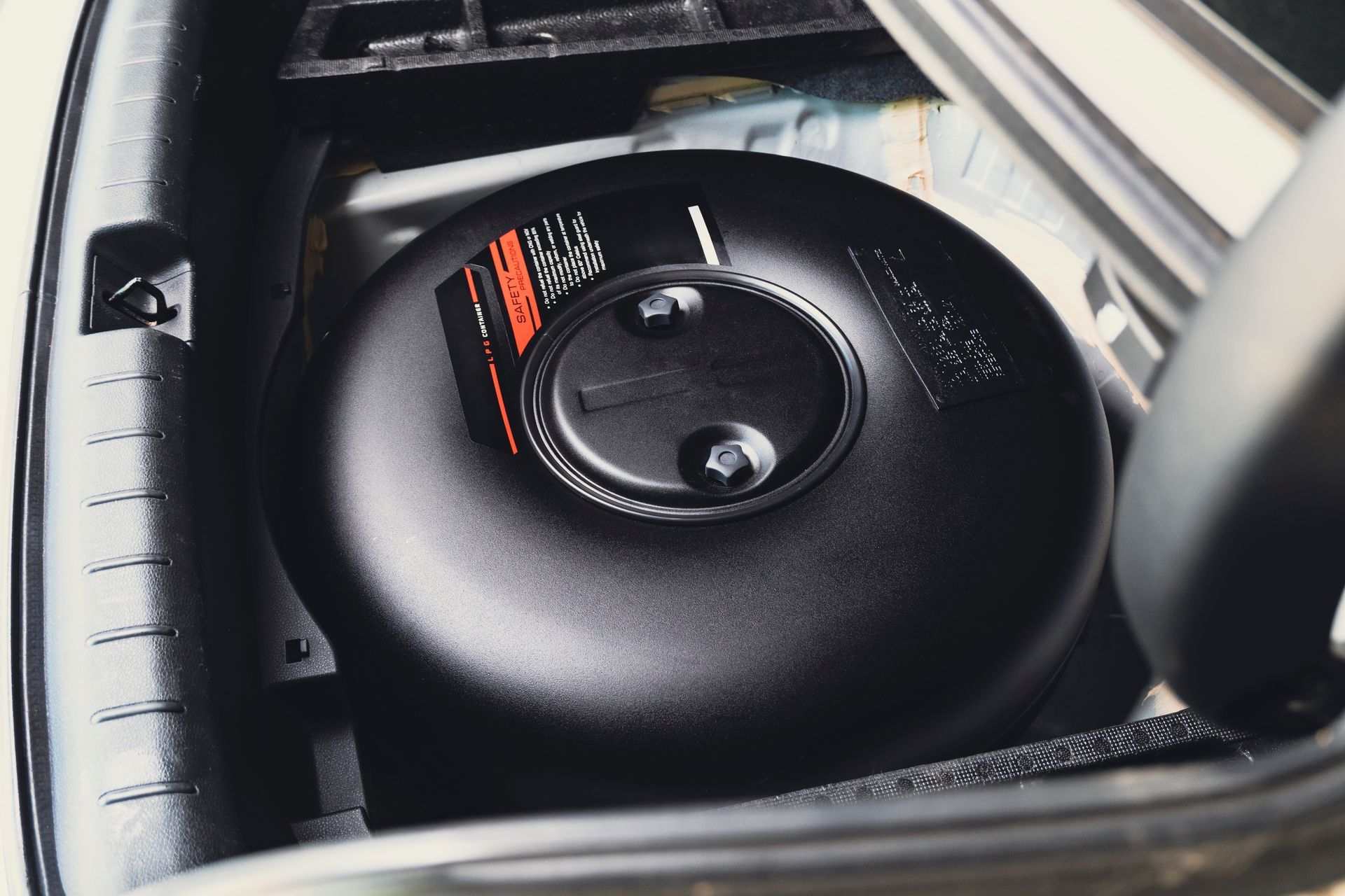 Réservoir circulaire à l'intérieur du coffre d'une voiture.