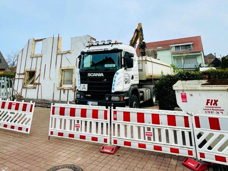Ein Scania-Lkw steht vor einem im Bau befindlichen Gebäude.