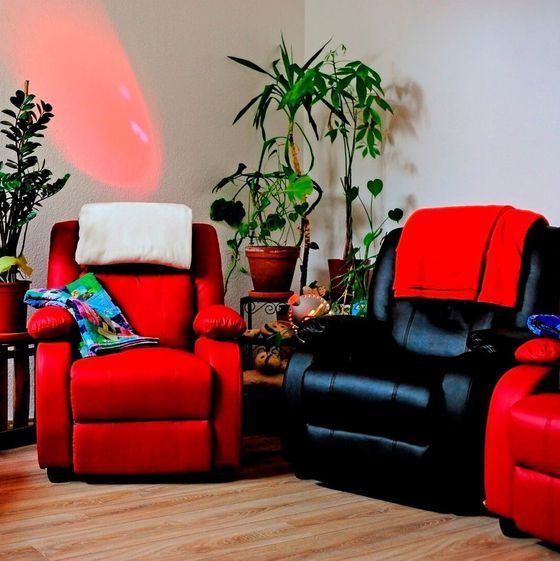 Tagespflege Sitzbereich mit gemütliuchen roten und schwarzen Sesseln