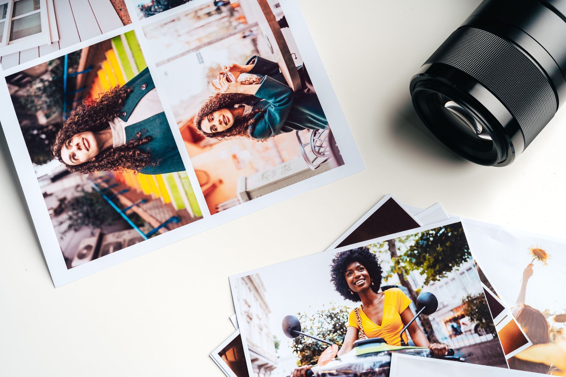 Una pila de fotos y una cámara sobre una mesa.