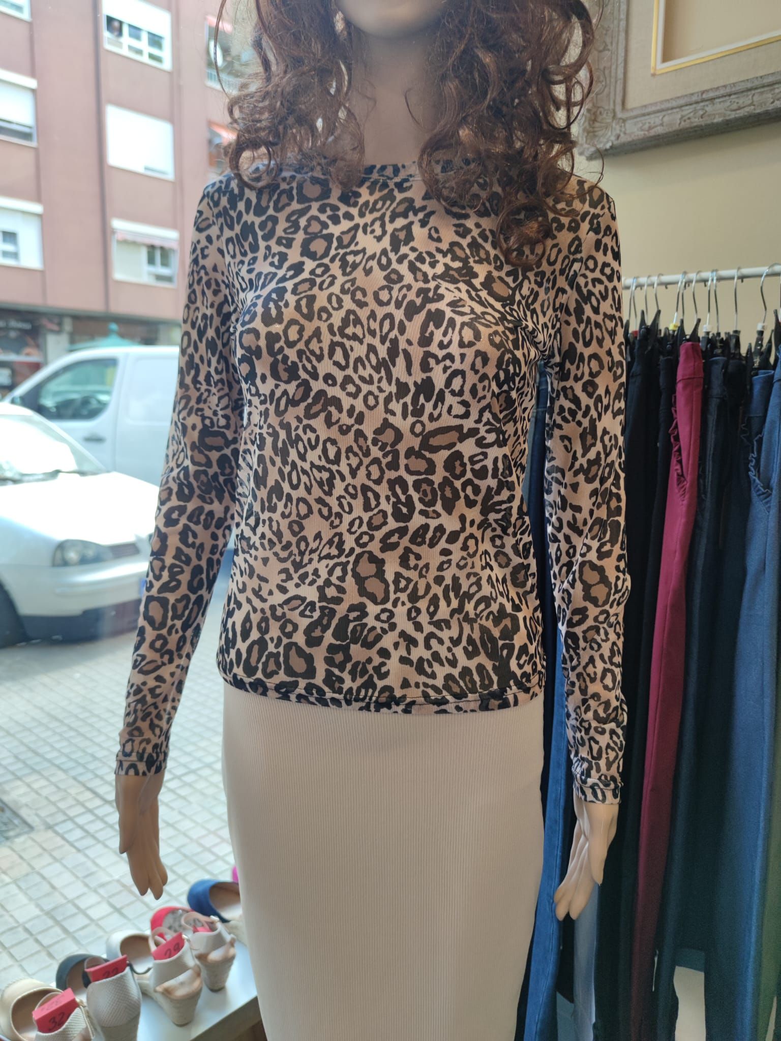 Un maniquí lleva una blusa y una falda con estampado de leopardo.
