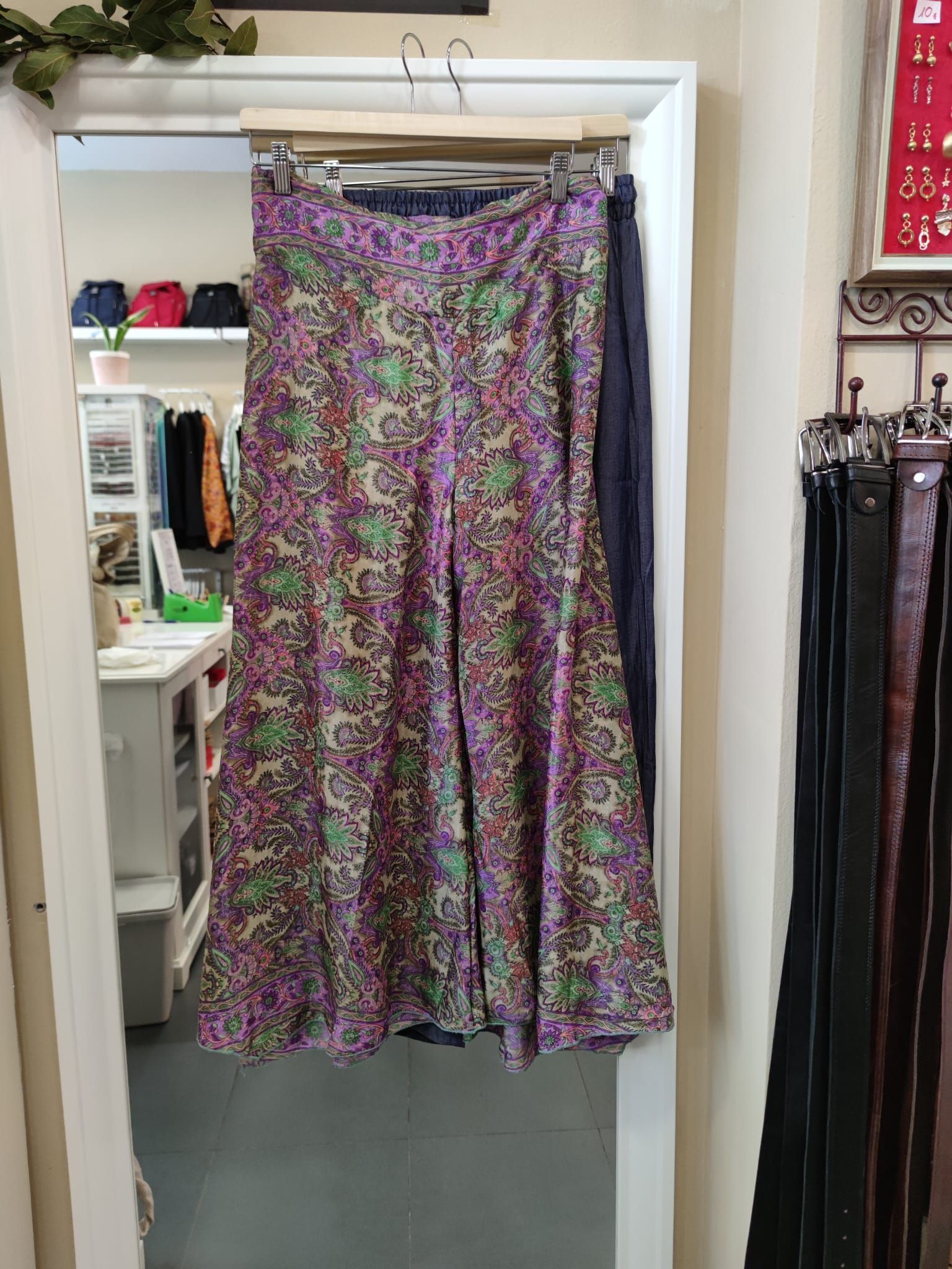 Una falda morada está colgada en un armario junto a un espejo.