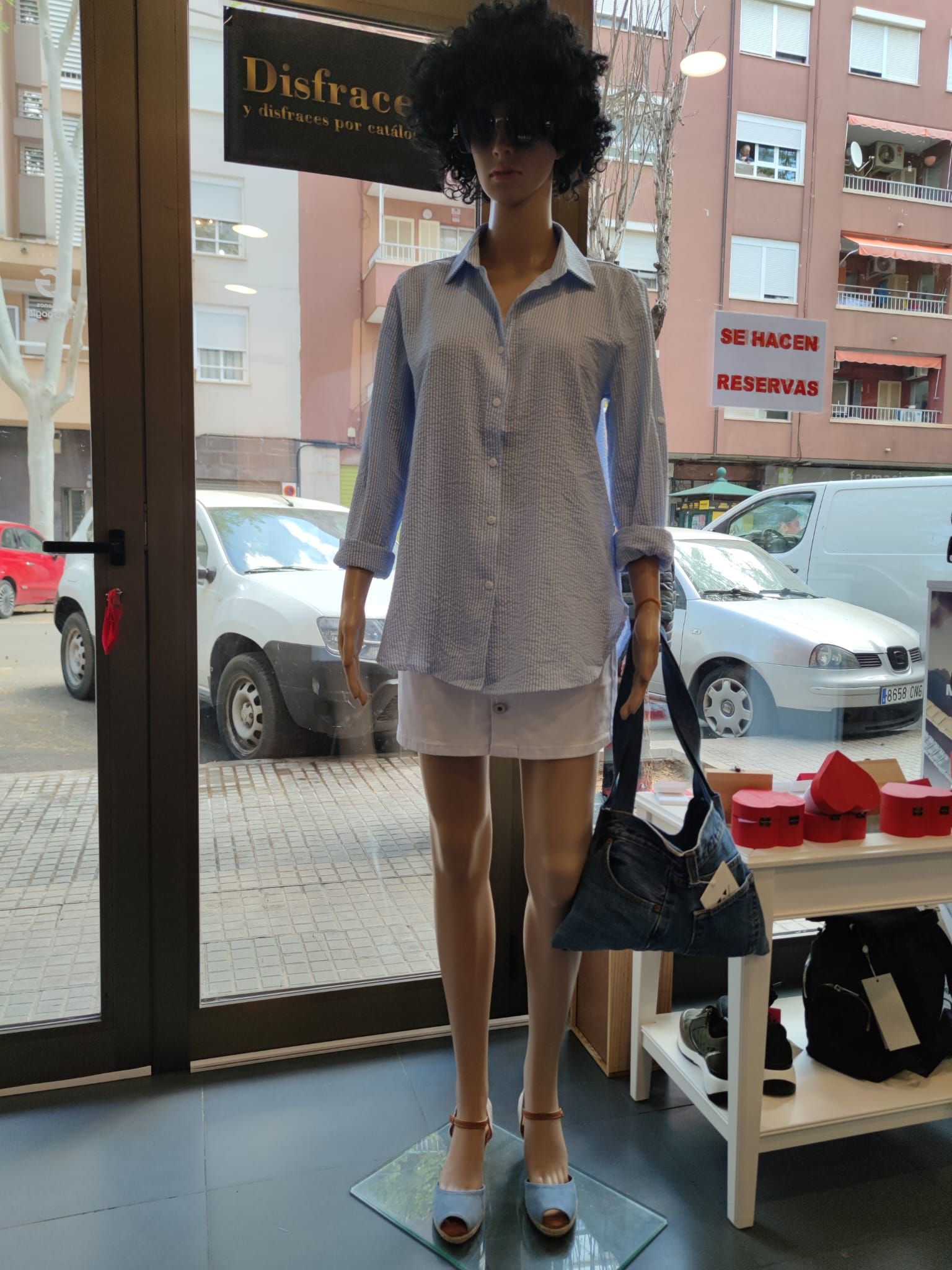 Un maniquí con una camisa azul y pantalones cortos blancos.