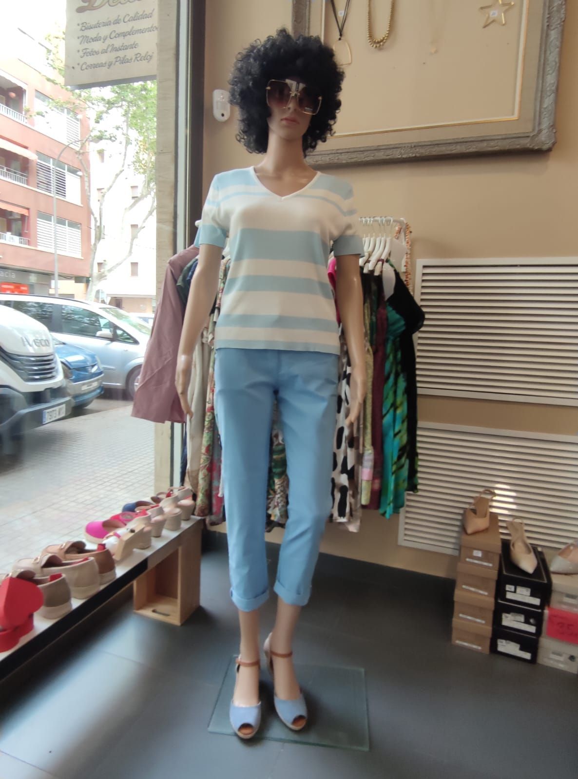 Un maniquí con una camisa a rayas y jeans azules.
