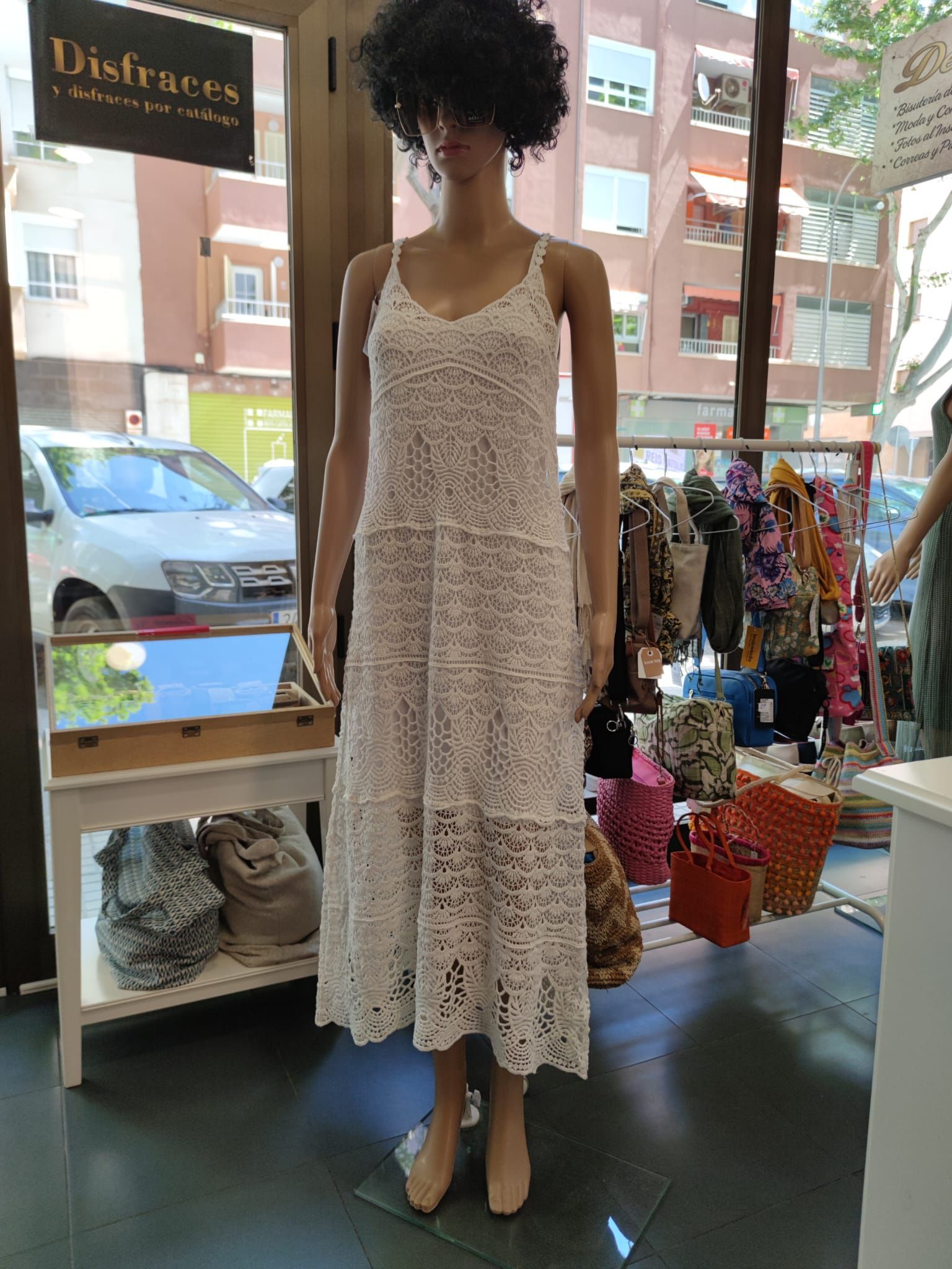 Un maniquí lleva un vestido de encaje blanco en una tienda.