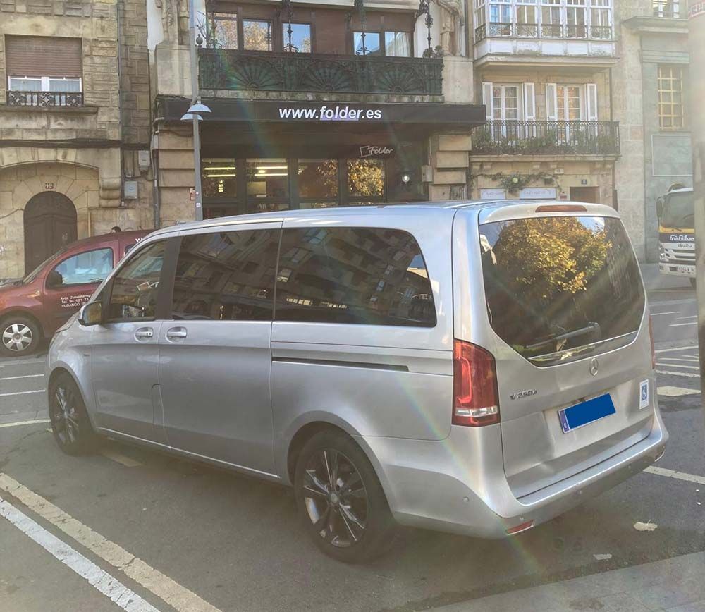 Una camioneta plateada está estacionada al costado de la carretera.