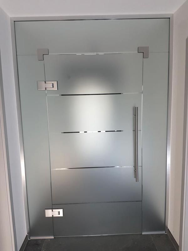 Milchglastür mit silbernen Beschlägen und horizontalen Milchglasstreifen, eingerahmt von einer passenden Glasplatte.