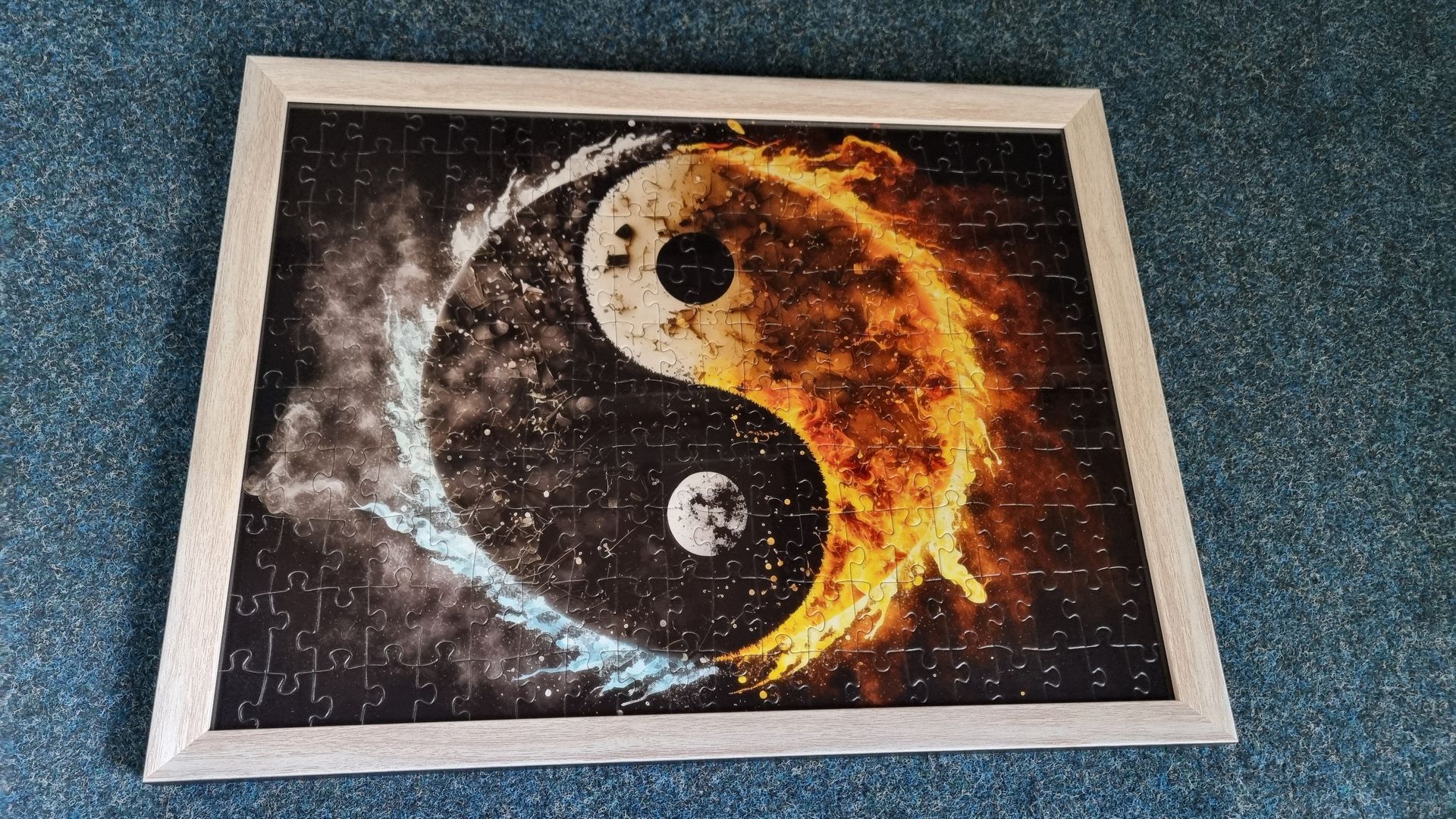 Gerahmtes Puzzle mit Yin- und Yang-Design; blaue und feuerorange Hälften; schwarz-weiße Details.