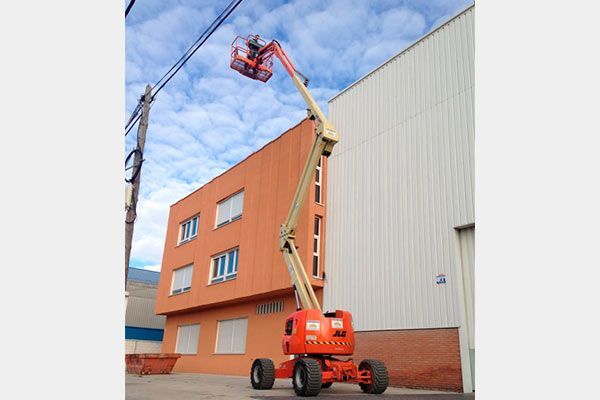 Un gran elevador aéreo de color naranja se encuentra sobre una superficie blanca.