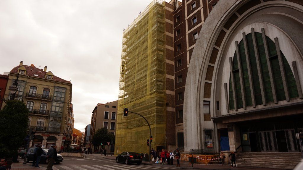 En una ciudad se está remodelando un edificio con andamios.