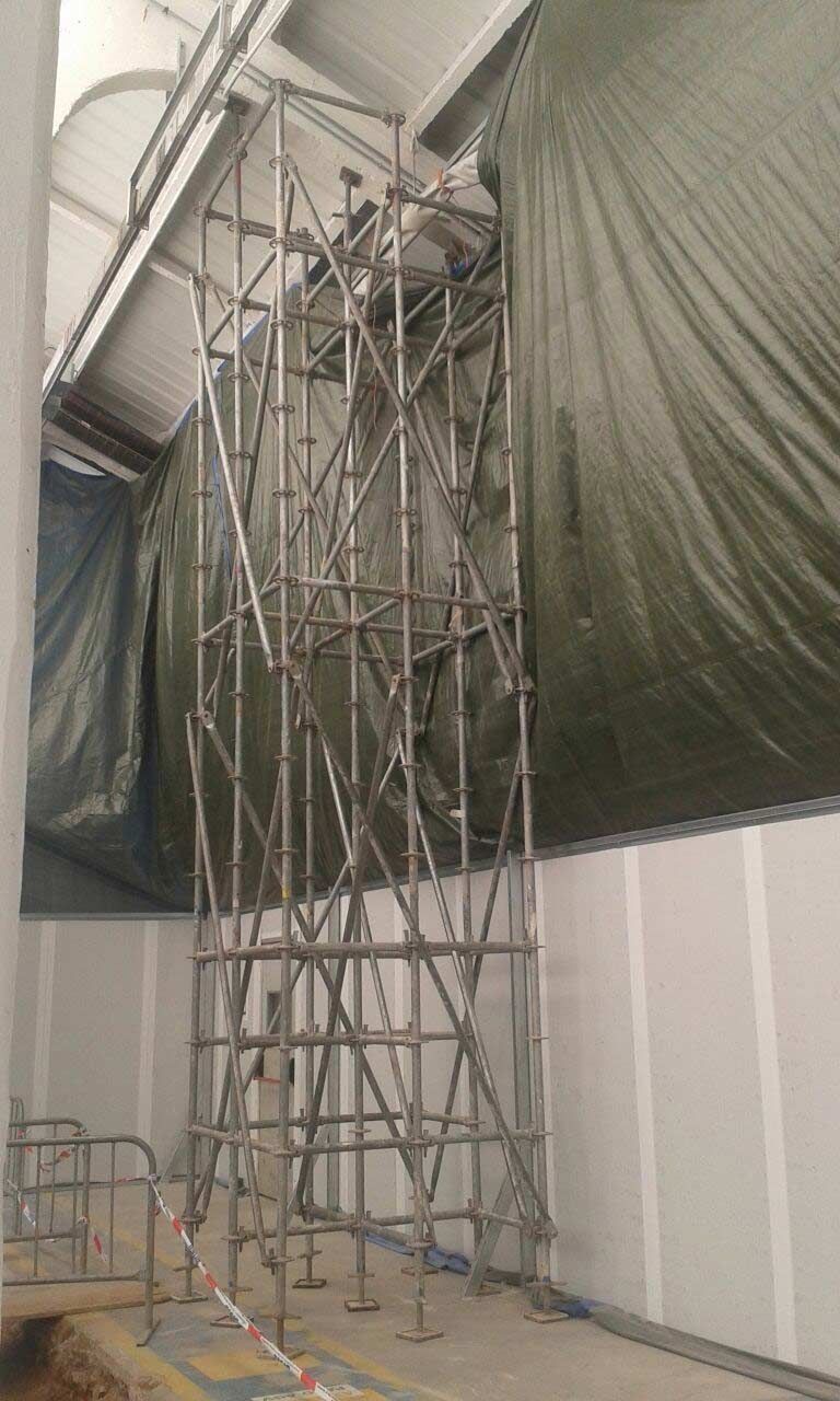 Un edificio en construcción con andamios y una lona en el techo.