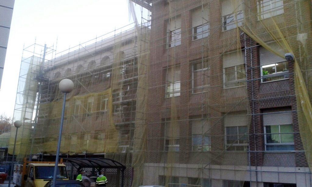 Se está remodelando un gran edificio con andamios a su alrededor.