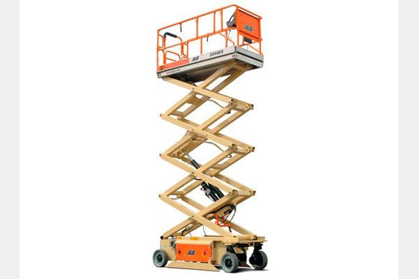 Un elevador de tijera está colocado encima de una superficie blanca.